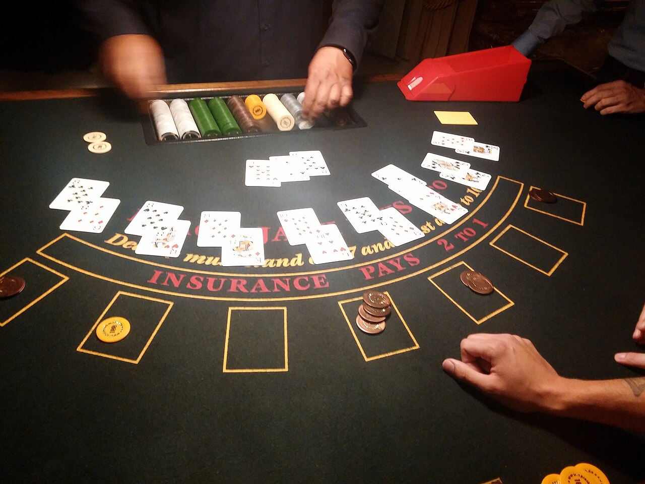 Dealer's upcard face up beside a player's two cards on a blackjack table