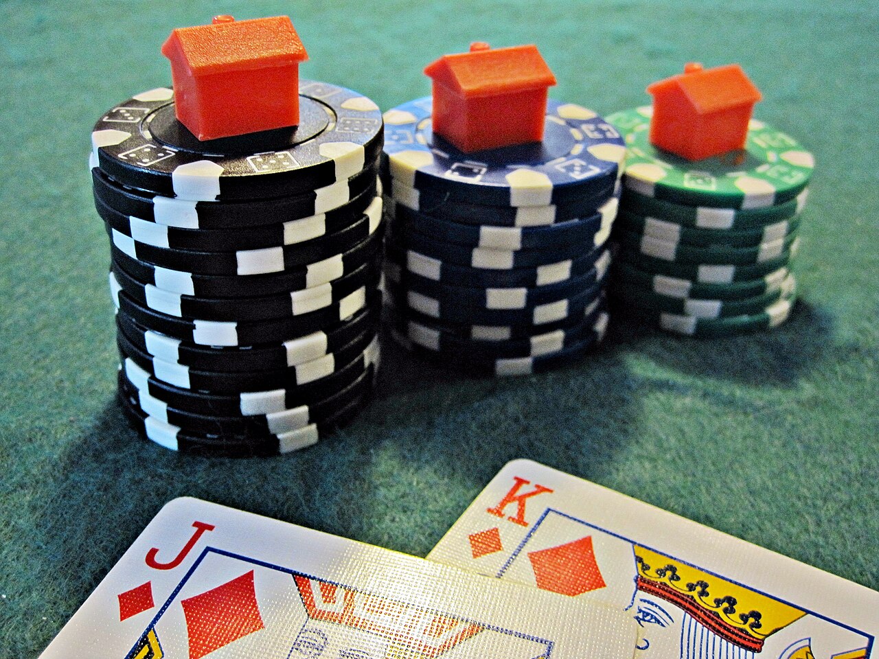 Chips stacked beside cards on a green baize casino table