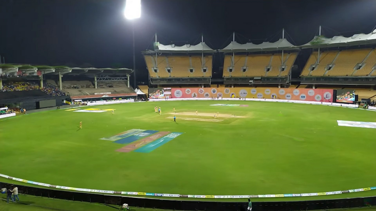 Full stand applauding during an evening match at a coastal cricket ground