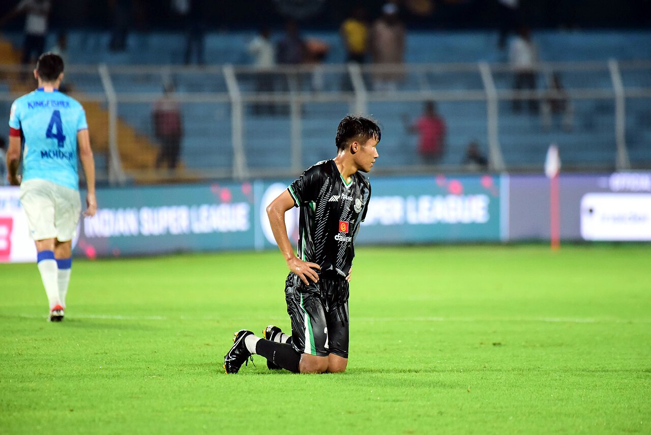 Indian Super League match under floodlights with a full stand behind the goal