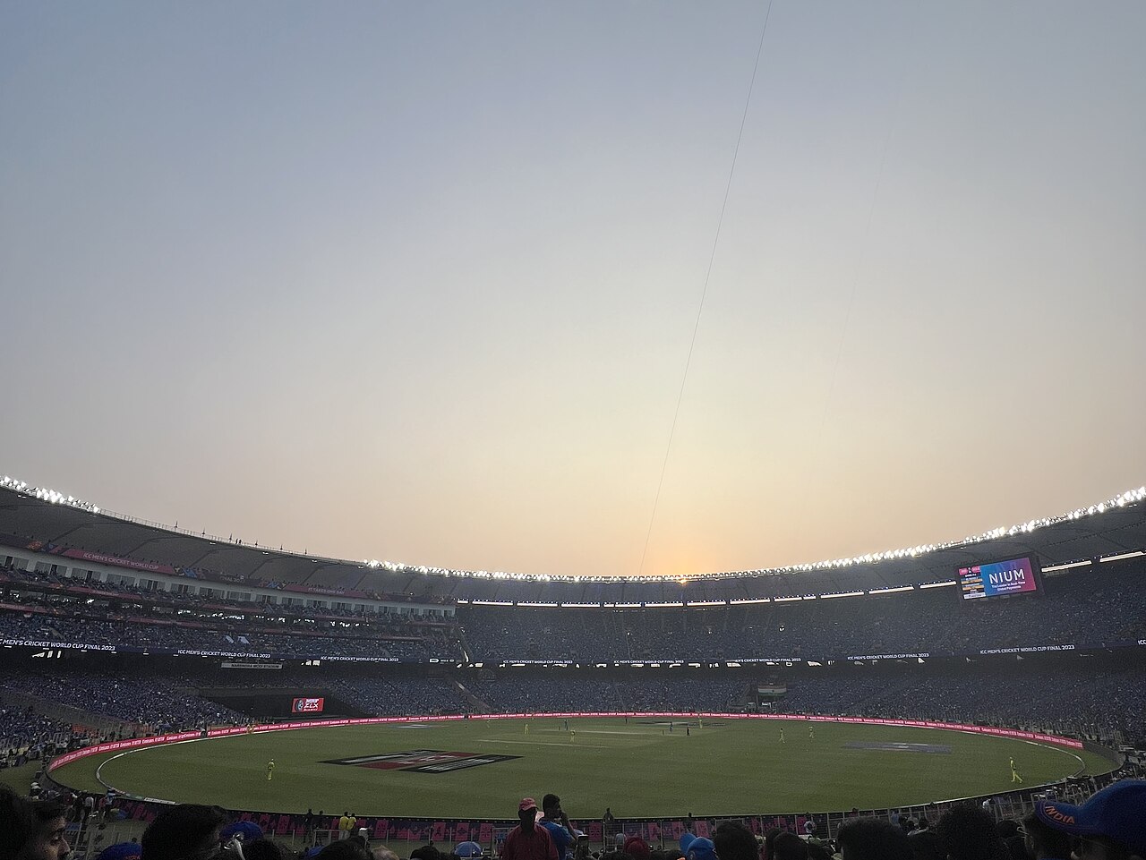Vast tiered bowl of a cricket stadium lit by a continuous ring of LEDs rather than floodlight towers