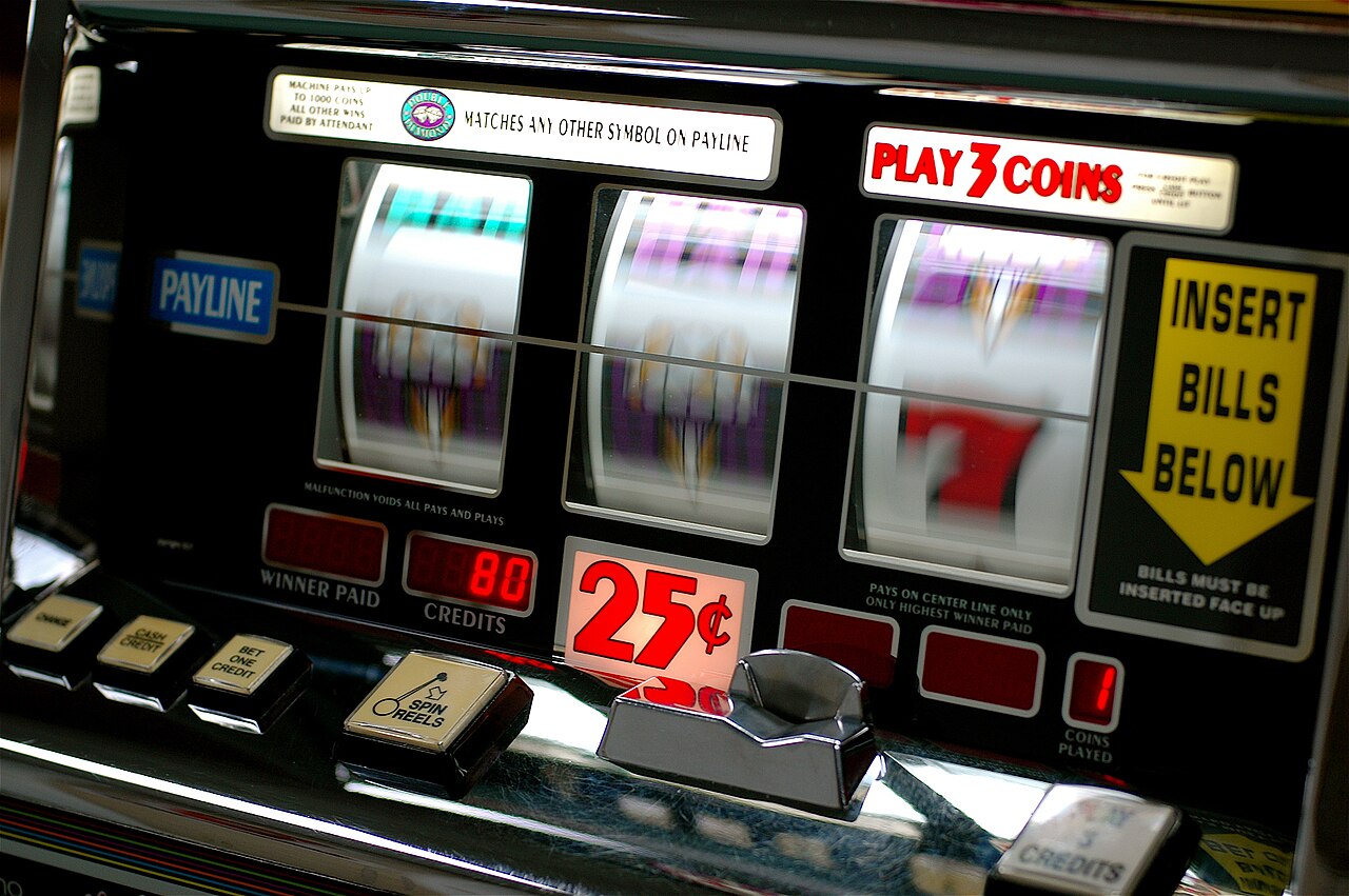 Slot reels mid-spin on a phone screen held in one hand