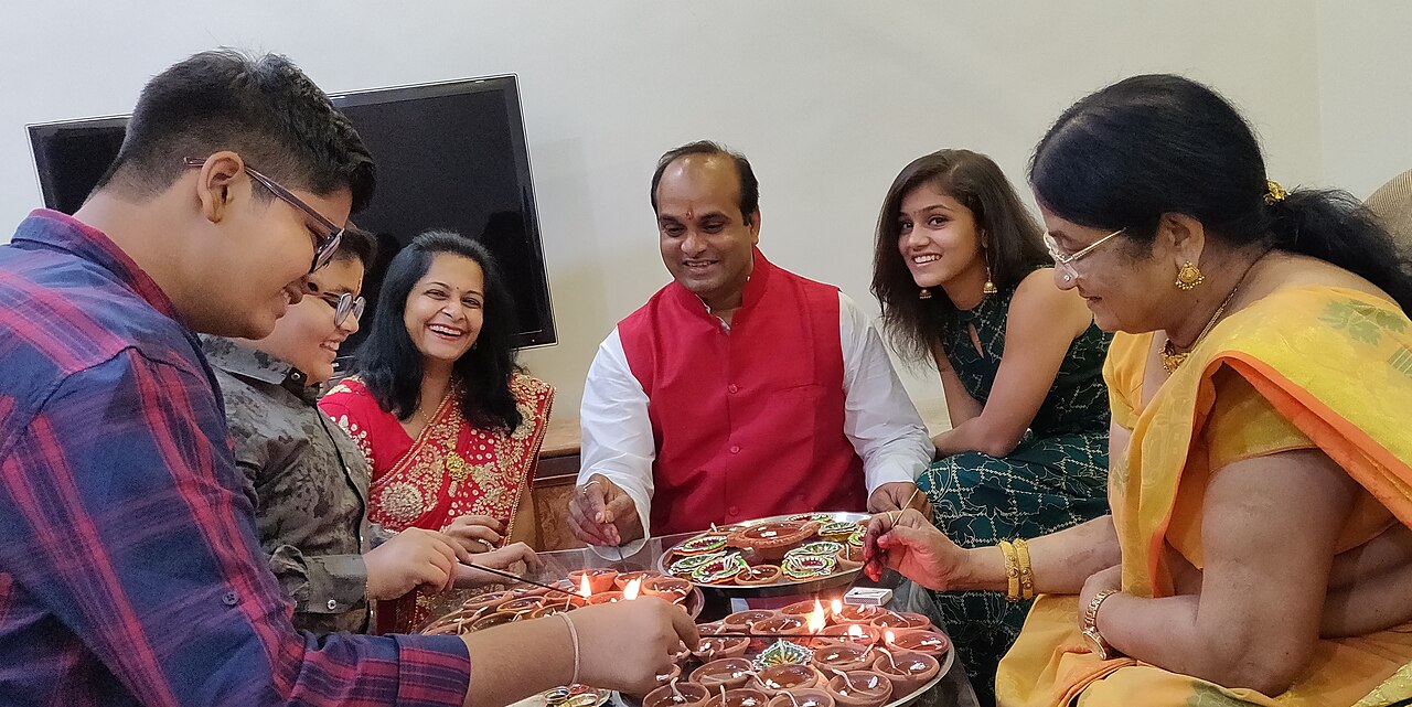Friends playing cards around a table during Diwali