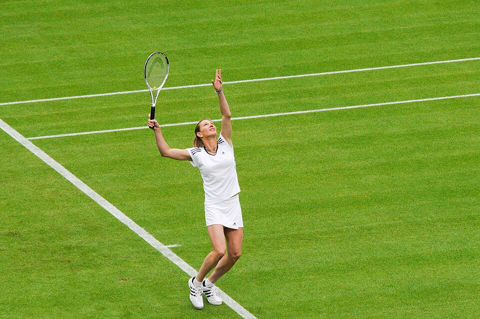 Tennis player serving on a hard court